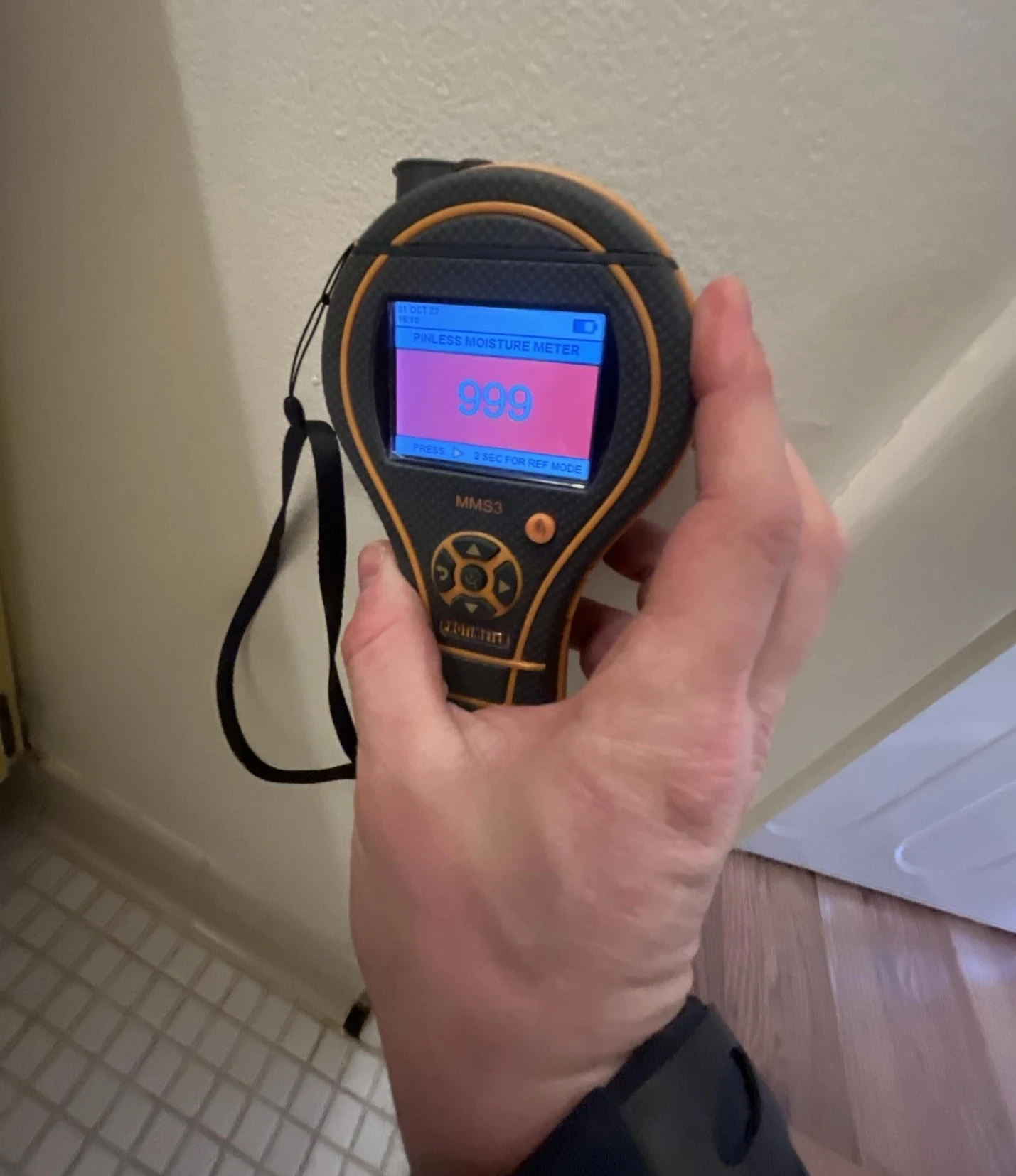 moisture meter reading high moisture levels in wall during water damage inspection
