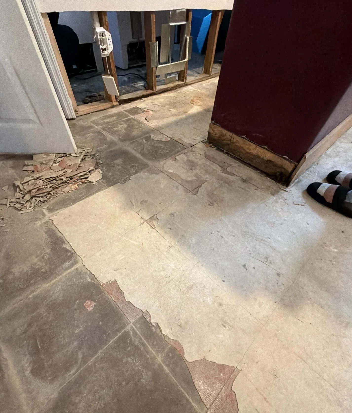 water damage demolition with removed flooring and exposed subfloor near wall framing after leak