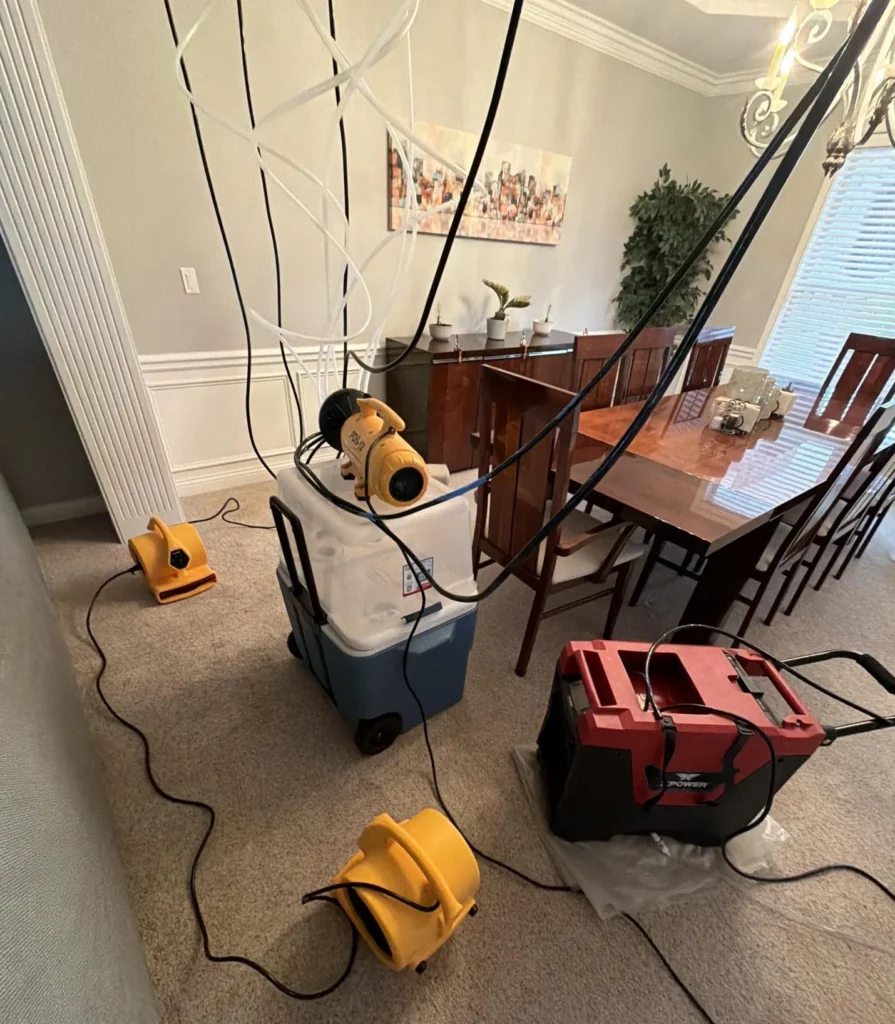 water damage drying setup in dining room with air movers, dehumidifier, and injectidry system hoses